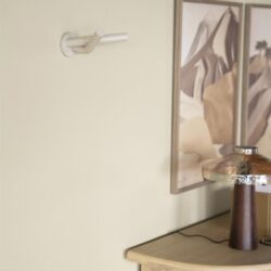 Moderne witte kapstok aan de muur met houten meubel en kunstwerk op de achtergrond - Mokana Meubelen.