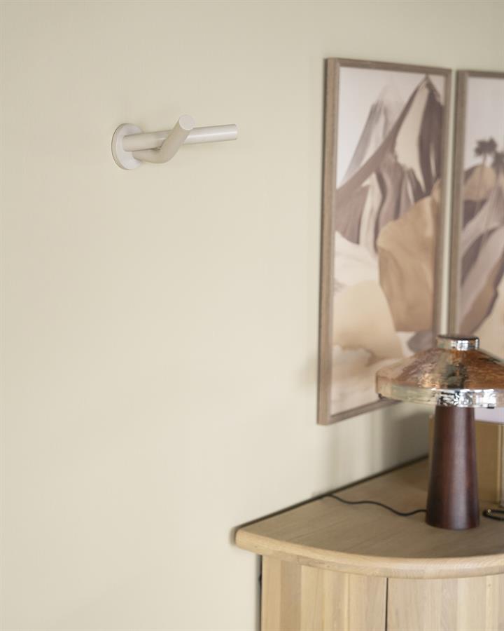 Moderne witte kapstok aan de muur met houten meubel en kunstwerk op de achtergrond - Mokana Meubelen.