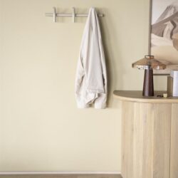 Lichte muur met houten kapstok en handdoek, mooie houten console met decoratief items en wandkunst, natuurlijke en minimalistische interieurstijl, meubelen van Mokana Meubelen, sfeer en elegantie in huis.