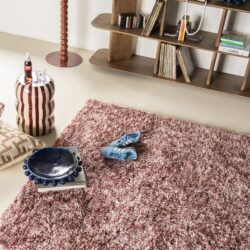 Schommelstoel van hout met boekenkast en decoratieve accessoires, vintage woonkamer interieur, Mokana Meubelen.