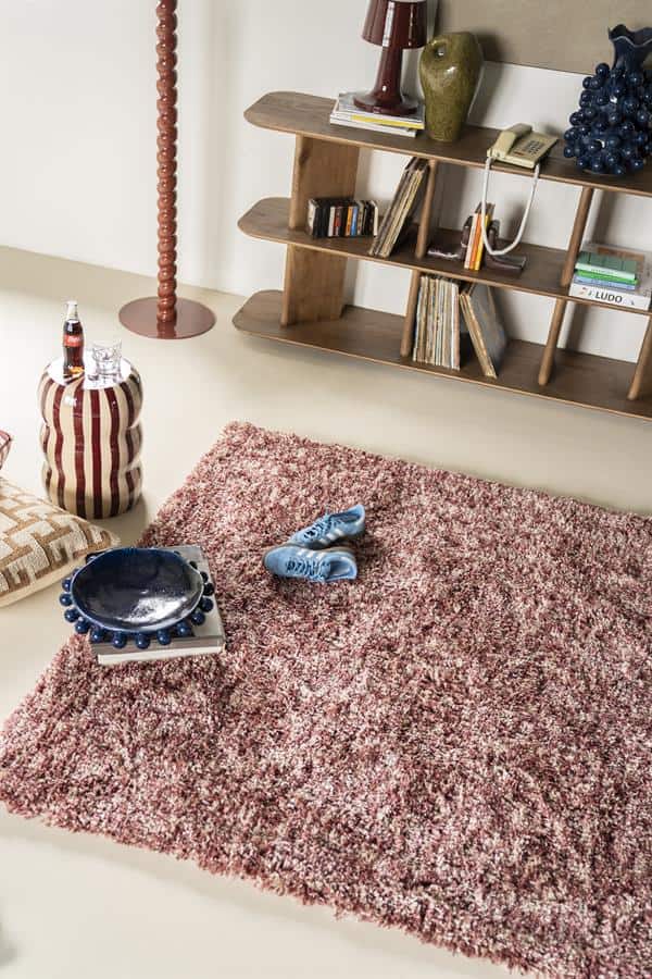 Schommelstoel van hout met boekenkast en decoratieve accessoires, vintage woonkamer interieur, Mokana Meubelen.