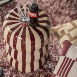 Kleine ronde salontafel met een uniek rood-wit gestreept patroon, ideaal voor Scandinavisch interieur.