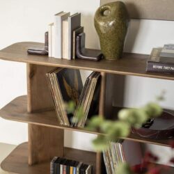 Natuurhouten boekenkast met decoratieve vazen en kunstboeken, ideaal voor een stijlvol interieur.