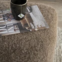 Zachte, wollen meubelpoef in neutraal bruin, ideaal voor woonaccessoires en comfort.
