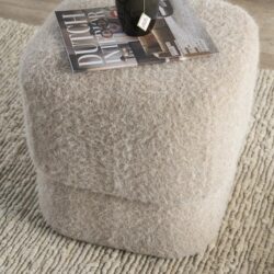 Vloerlamp met zachte, wollige bekleding op een ronde basis, ideaal voor een warme, gezellige woonruimte.