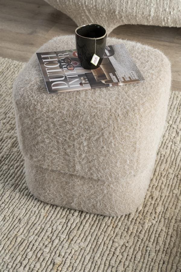 Vloerlamp met zachte, wollige bekleding op een ronde basis, ideaal voor een warme, gezellige woonruimte.