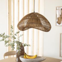Elegante houten hanglamp boven een eettafel met vazen en fruit in een modern interieur.