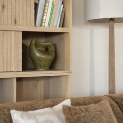 Grote houten boekenkast met decoratieve vazen en boeken, moderne woonkamer inrichting, natuurlijke materialen en warme sfeer,stijlvol meubelontwerp voor woonkamer of leeshoek.