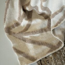 Zweeds tapijt met beige en bruin geometrisch patroon, perfect voor moderne interieurdecoration.