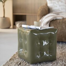 Kunststoffen bijzettafel in groen met een ruw oppervlak, op een beige tapijt in een stijlvolle woonkamer, modern woondecor, Mokana Meubelen.