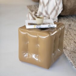 Zachte beige bijzettafel met plooien, modern design, in een woonkamer met zachte texturen en een leeslamp. Perfect voor een stijlvolle en functionele inrichting.