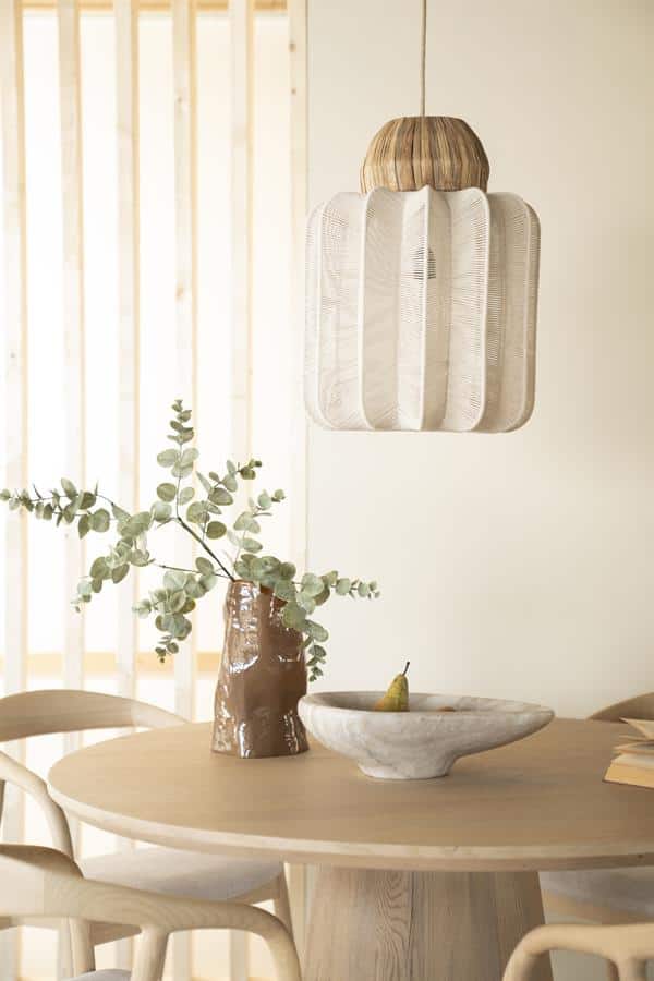 Rustieke houten hanglamp boven eettafel met natuurlijke uitstraling, passend bij modern minimalistische interieurstijl.