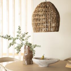 Rustieke houten hanglamp boven eettafel met natuurlijke decoratie en duurzame meubels, modern interieur design.