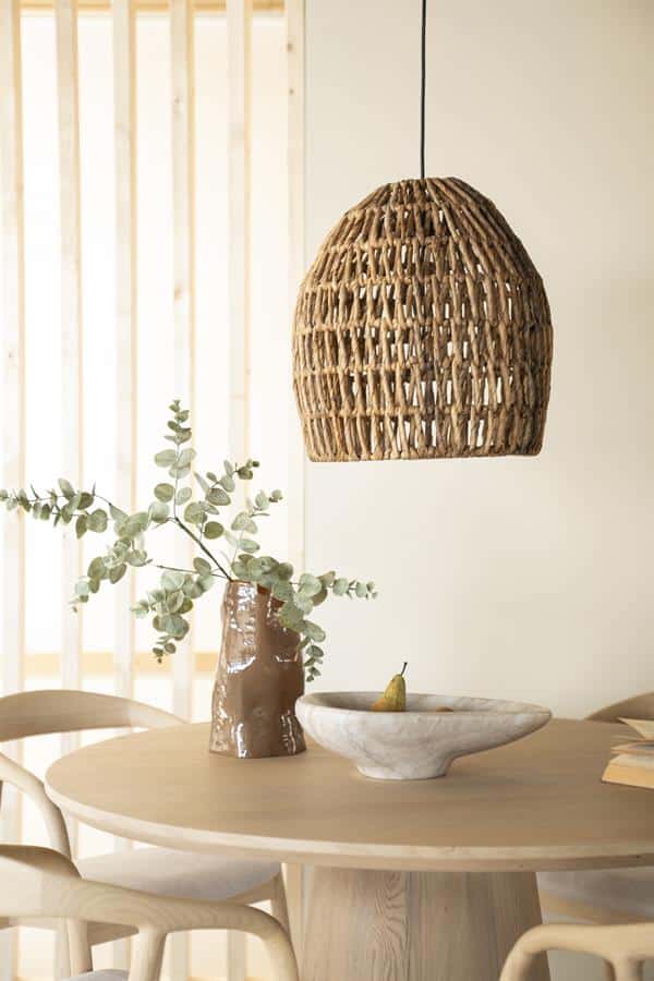 Rustieke houten hanglamp boven eettafel met natuurlijke decoratie en duurzame meubels, modern interieur design.