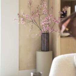 Bloemstuk met roze bloemen in donkere vaas en houten meubels, moderne interieurdecoratie, woonaccessoires voor stijlvolle woningen.