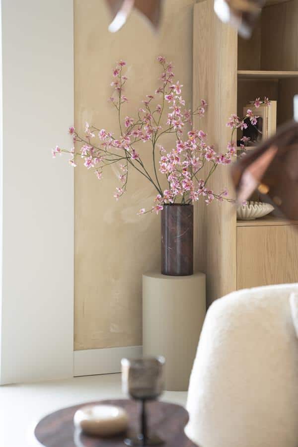 Bloemstuk met roze bloemen in donkere vaas en houten meubels, moderne interieurdecoratie, woonaccessoires voor stijlvolle woningen.