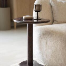 Marmeren bijzettafel met donker glazen kandelaar en sierobjecten in een moderne, gezellige woonkamer. Perfect voor stijlvolle interieurs en interieurdesign.