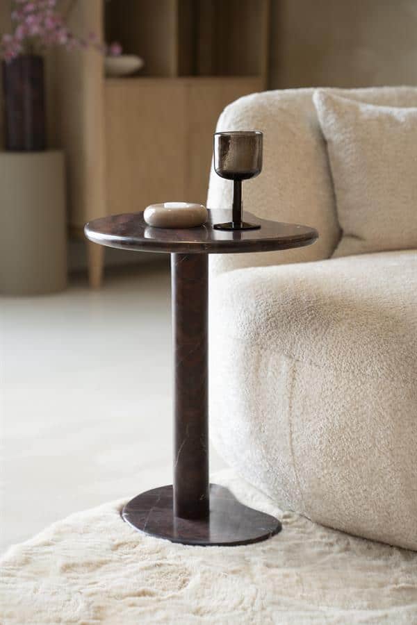 Marmeren bijzettafel met donker glazen kandelaar en sierobjecten in een moderne, gezellige woonkamer. Perfect voor stijlvolle interieurs en interieurdesign.