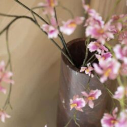 Zweefrozen bloemen in een glazen vaas op een bijzettafel, decoratief en stijlvol interieuraccessoire.