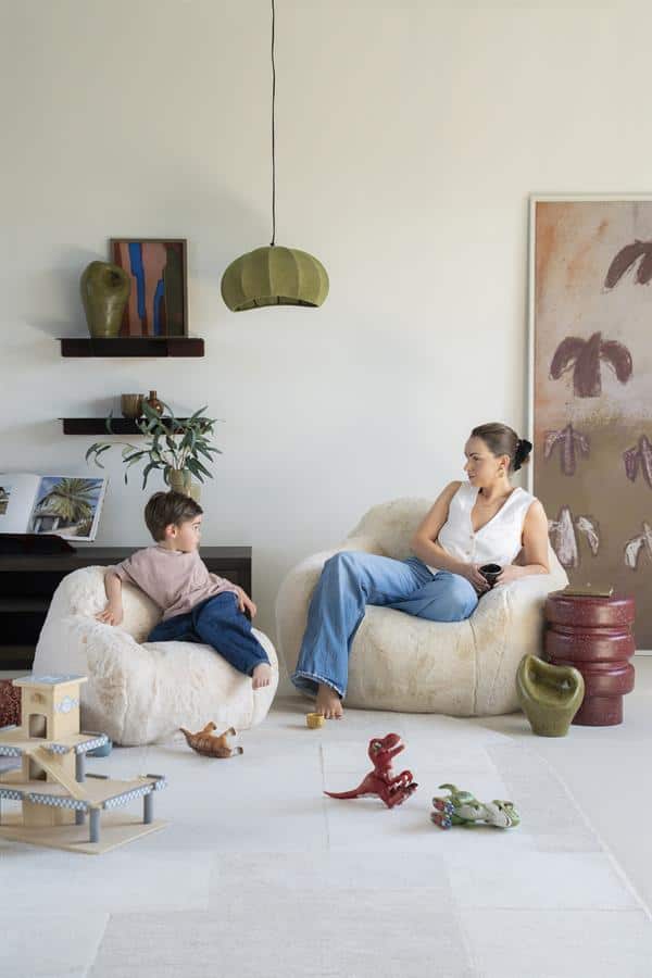 Zachte, comfortabele zandkleurige fauteuils in een modern woonkamer met speelse kleurtjes, perfect voor een gezellige gezinsspelletjes en ontspanning.