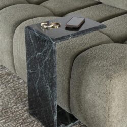 Stijlvolle zwarte marmeren bijzettafel naast een groen stoffen bank, ideaal voor woondecoratie en praktisch gebruik in woonkamer.