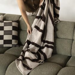 Luxe gewoven plaid in beige en bruin met franjes, perfect voor comfortabel wonen en stijlvolle interieurdecoratie.