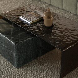 Mooi modern salontafel van zwart marmer met een reliëf details, ideaal voor stijlvolle interieurs, afgewerkt met accessoires zoals een boek en keramische vazen, perfect voor een luxe woonkamer.