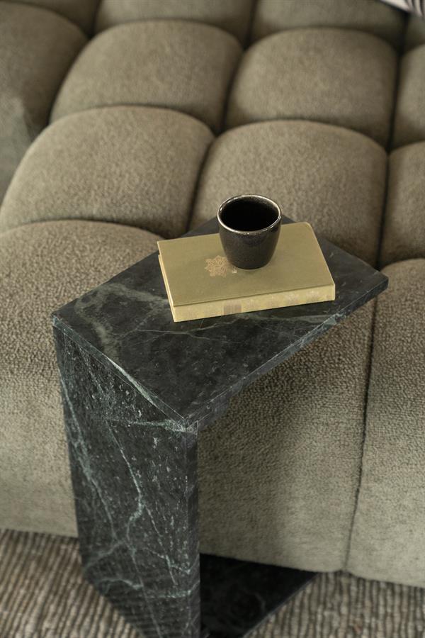 Stenen bijzettafel met zwarte ceramic mug en boek op bank in woonkamer.