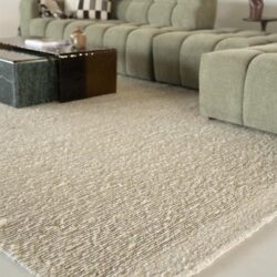 Zeer zacht beige en crème kleurig vloerkleed met een fijne textuur in een modern woonkamer.