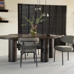 Stoel met vilt bekleding en metalen frame, donker houten eettafel met bloemstuk, modern interieur met wanddecoratie en planten, hoogwaardige meubels van Mokana Meubelen, perfect voor een stijlvolle eetruimte.