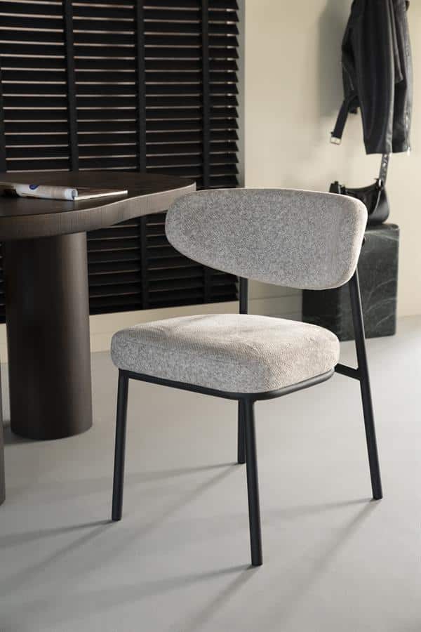 Stijlvolle moderne stoel met lichtgrijze bekleding en zwart metalen poten, perfect voor een eigentijdse eetkamer of kantoorruimte.