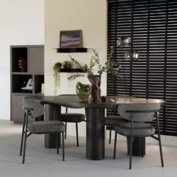 Elegante zwarte eettafel met drie bijpassende fauteuils en decoratieve vazen en bladeren, perfect voor een moderne en stijlvolle eetkamer.