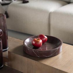 Walnoottinten houten salontafel met een mozaïek patroon en een ronde marmeren schaal met twee rode appels, modern en elegant wooninterieur, Mokana Meubelen, hoogwaardige houten meubelen, sfeervol woonkamer design.