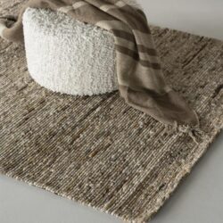 Gevlochten wollen vloerkleed met natuurlijke uitstraling, perfect voor een modern interieur.