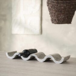 Elegante wijnfles in een uniek, golvend houten wijnrek op een modern houten tafel, met een kunstzinnig hanglamp en abstract muurkunst op de achtergrond, perfect voor stijlvol wonen.