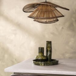 Mooie houten hanglamp boven een Moderne eettafel met groene marmeren vazen en schaal, Scandinavisch interieur detail.