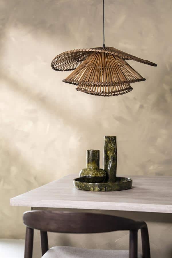Mooie houten hanglamp boven een Moderne eettafel met groene marmeren vazen en schaal, Scandinavisch interieur detail.