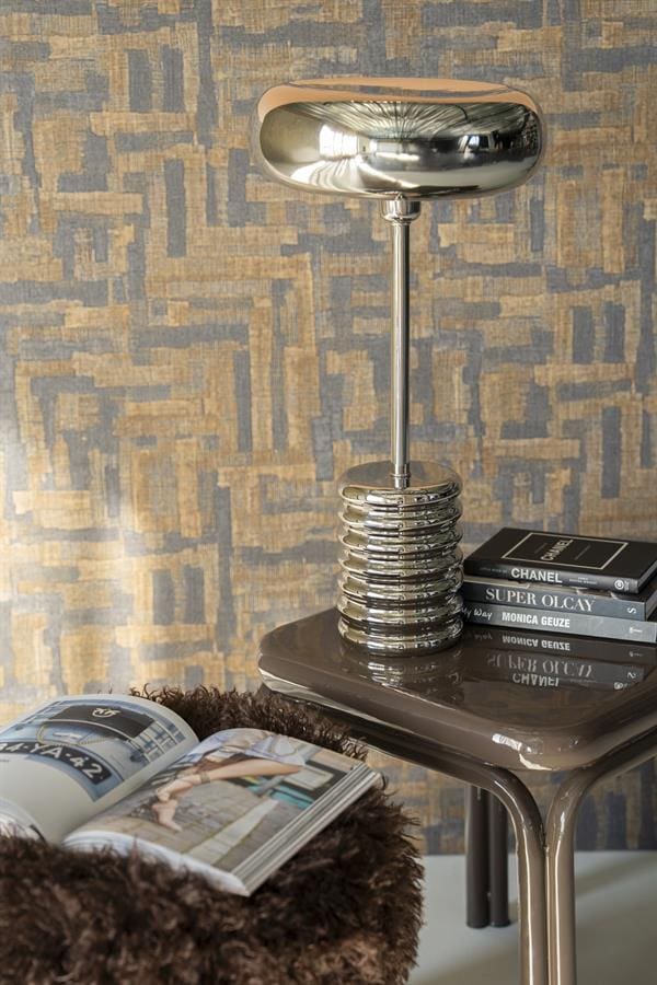 Elegant moderne metallic tafelaccessoire op zwart bijzettafeltje, stijlvolle interieurdecoratie met boeken en luxe afwerking voor een eigentijdse woonstijl.