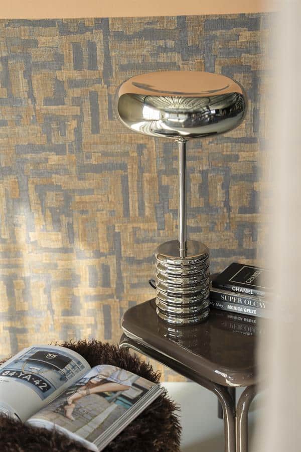 Modern chrome tafel lamp op bijzettafel in interieur, stijlvol decor met design meubels en boeken, perfect voor een luxueus en eigentijds interieurconcept.