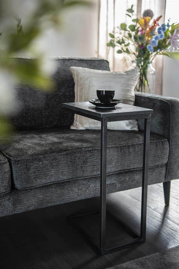 Stijlvolle landelijke salontafel naast elegante bank, perfect voor modern interieur.