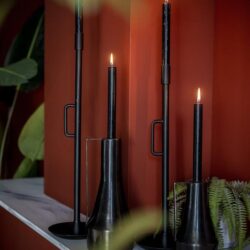 Elegante zwarte kandelaars met brandende kaarsen voor sfeervolle inrichting en decoratie.