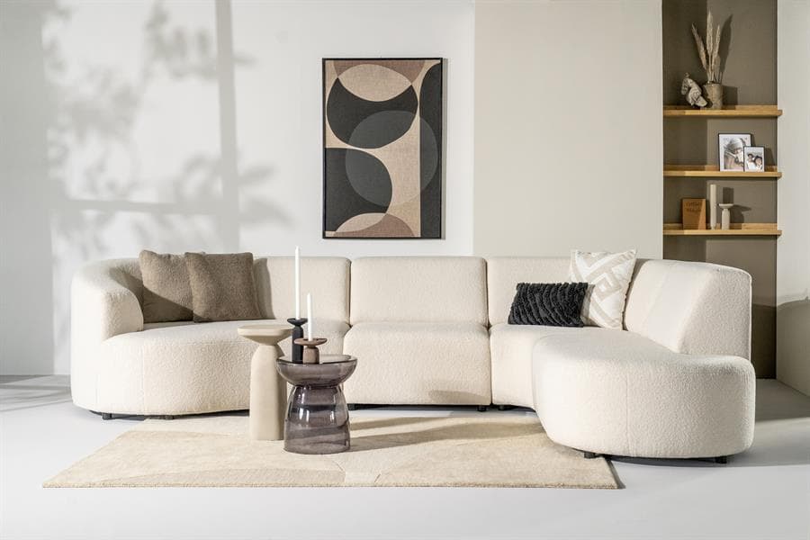 Zachte witte L-vormige bank in modern wooninterieur met decoratieve kussens en bijzettafels, perfect voor stijlvolle en comfortabele zithoeken.