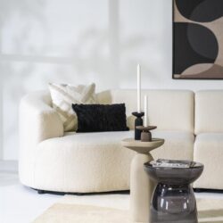 Moderne bank met bijpassende sierkussens en stijlvolle bijzettafels in een strakke woonkamer.