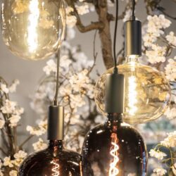 Geleidelijke close-up van moderne hanglampen met glazen bolvormen en warme filamentverlichting, perfect voor stijlvolle woonkamers en eetkamers met meubelen van Mokana.