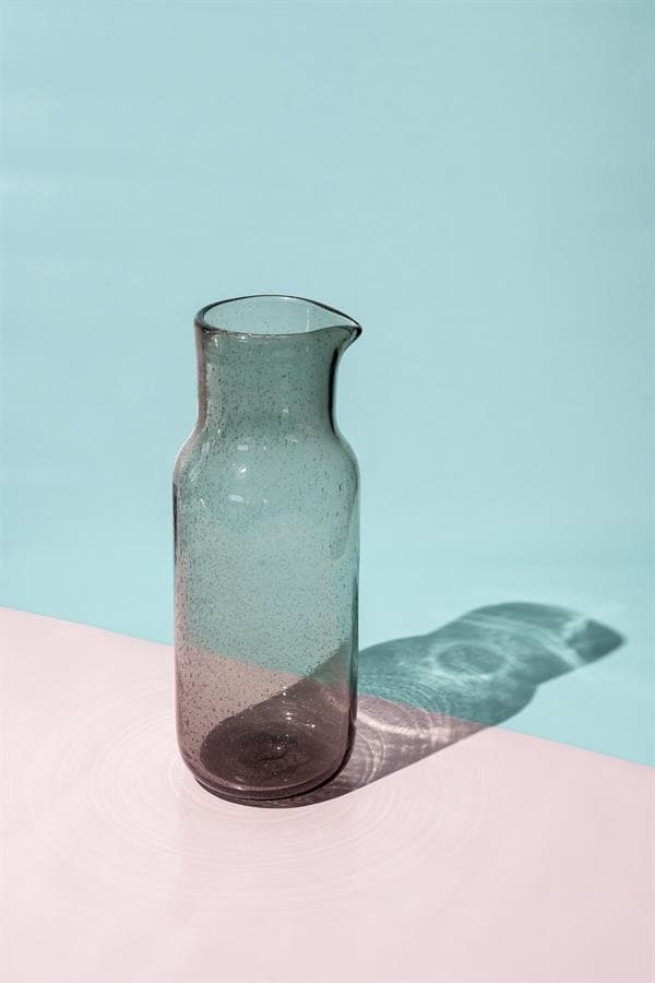 Gelukte glazen vaas op pastelkleurige ondergrond, perfect voor modern interieur en decoratie.