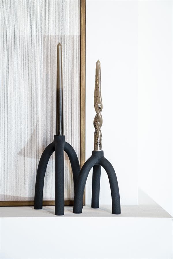 Strakke moderne kaarsen met uniek design op zwarte metaal voet, geschikt voor exclusieve interieurdecoratie.