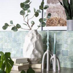 Gezicht op een moderne interieurdecoratie met groene planten, wandtegels en kaarsen, perfect voor stijlvolle woonkamers en natuurlijke sfeer.