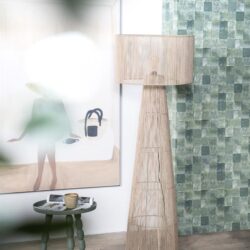 Unieke houten vloerlamp en decoratieve accessoires in modern huisinterieur met groene tegels en kunstwerk.