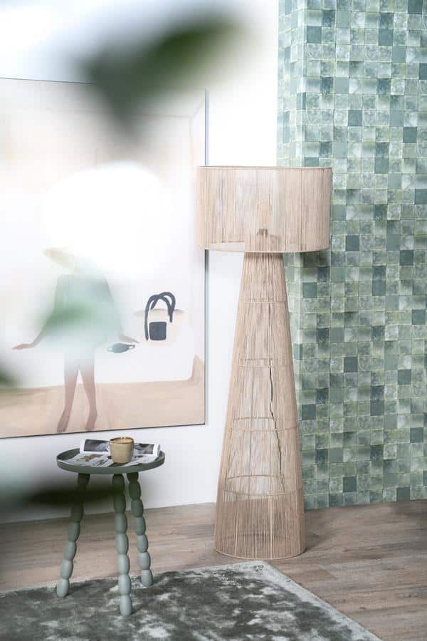 Unieke houten vloerlamp en decoratieve accessoires in modern huisinterieur met groene tegels en kunstwerk.
