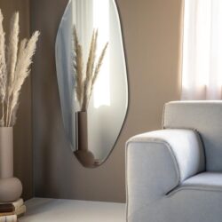 Elegant design woonkamer met large oval spiegel, beige muur en stijlvolle decoratie, passend bij Mokana Meubelen.